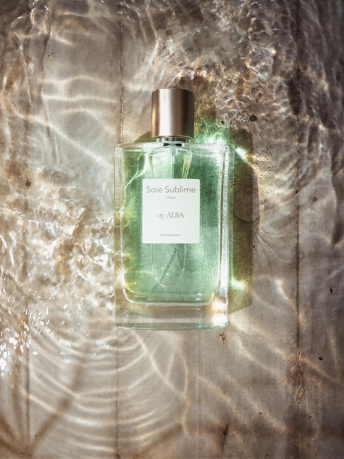 ALBA bottle lying in shallow water under the rippled light of morning
